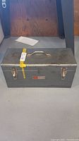 Closed metal toolbox with handle and label