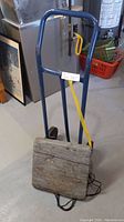 Steel hand truck, blue frame with yellow strap, and attached wooden dolly