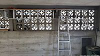 Wide view showing the aluminum extension ladder supported horizontally with roof brackets and the step ladder standing upright against the wall.