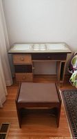 Dressing table with glass top protector and embroidered mats beneath