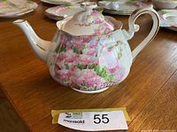 Front right view of teapot with lid showing blossom pattern and gold trim.