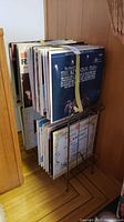 Full view of record rack filled with vinyl records with a yellow strap holding some records upright.