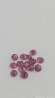 Loose round cut red-pink rubies on white background