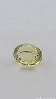 Close up of oval cut lemon citrine gemstone showing facets and clarity.