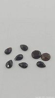 Close-up photo of eight natural black onyx gemstones showing different cuts and butterscotch hues.