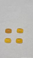 Four cushion cabochon cut caramel opals on plain white background, arranged in a square pattern.