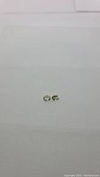 Two small light pastel green oval cut sillimanite stones on a white background.