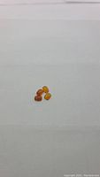 Four small natural Mexican opal gemstones in caramel and orange colors, cushion cabochon shape, displayed on a white background.