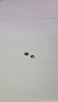 Pair of small oval faceted tourmaline gemstones on a white background, showing two stones separated but close together.