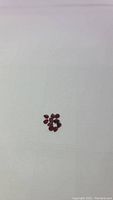 Ten pear-shaped cherry red garnet gemstones on a white background, top view showing color and clarity.