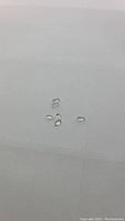 Close-up of five oval cut white petalite gemstones on a plain background, highlighting transparency and size.