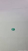 Single vivid green onyx gemstone shown against a plain white background, highlighting the stone's shape and color.
