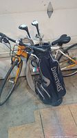 Photo showing Spalding golf bag filled with mixed golf clubs, including irons and woods.