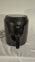 Front view of the T-fal black air fryer showing the outer body and handle.
