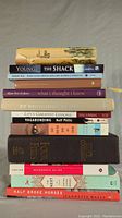 Photo showing a stack of 11 miscellaneous books including titles by various authors.