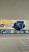 Box showing the Cricut Expression electronic cutter and examples of craft projects.