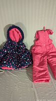 Toddler size 24 months snow suit set itemized with navy blue and heart print jacket with pink fleece lining and pink snow pants