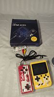 Yellow SUP retro handheld console still in plastic packaging with original blue box and AV cables