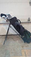 Golf bag standing with clubs visible, showing bag design and wear.