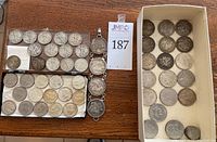 Overview of silver dollar coins, half dollar coins, and the coin bracelet in trays and box