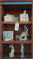 Top and middle wooden shelves with five figurines and boxes