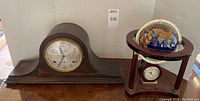 Sessions mantel clock and gemstone globe clock on mahogany stand together on table