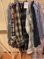 Group shot of hanging garments on rack with plastic covers