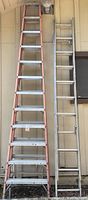 Full view of two tall ladders standing side by side; left ladder with aluminum and fiberglass rails, right is aluminum extension ladder.