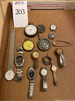Tray view of assorted pocket watches and wristwatches on cardboard packaging