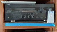 Front view of the Yamaha RX-V995 AV receiver showing buttons, knobs, and display.