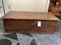 Closed cedar blanket box with dark stained exterior and visible keyhole.