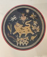 Full view of the framed circular tapestry showing the complete composition of the mythical animal and surrounding motifs.