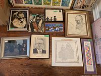 Overview of 12 framed Judaica artworks arranged on floor showing varied styles