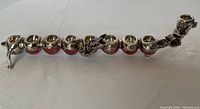 Clear top-down view of the cranberry glass menorah with silver overlay showing nine candle holders and decorative silver elements along the body.