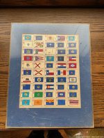 Hardcover stamp album with state flags slipcover on wooden surface