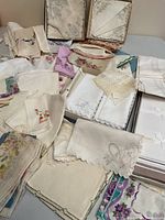Loose and boxed cotton handkerchiefs on table, including embroidered florals and plain styles