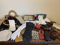 Overall view of gloves, bags and sunglasses laid out on a table