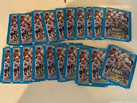 20 sealed packs of NHL Panini hockey stickers arranged on surface