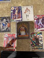 Photo showing multiple Panini Court Kings basketball cards from 2022-23 season, including notable players and a framed jersey patch card.
