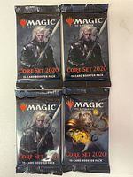 Four sealed Magic The Gathering Core Set 2020 booster packs, three with a male character holding a sword and one with a fiery creature on the packaging.