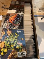 Long box filled with neatly organized bagged and boarded comics, showing Spider-Man and a DC Universe cover.