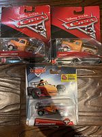 Lot of three Disney Pixar Cars sealed figurines: two Smokey trucks and one Clutchgoneski racing car.