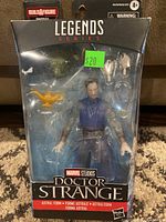 Front view of the sealed Doctor Strange action figure in blister packaging showing the figure, two interchangeable hands and a golden lamp accessory.