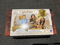 Front of the sealed box showing Harry Potter logo, Quidditch theme, age recommendation, and photo of children playing.