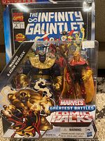 Full front view of sealed Marvels Greatest Battles Comic Packs with Thanos and Adam Warlock figures and The Infinity Gauntlet comic book inside clear plastic packaging.