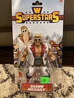 Front of sealed WWE Superstars Shawn Michaels action figure packaging showing figure and graphic illustration.