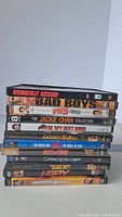 Stacked view of 12 DVD movies showing titles on spines