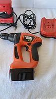 14.4V Black & Decker cordless drill with battery attached and charger placed nearby
