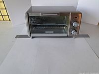 Front view of Black+Decker air fryer toaster oven showing glass door and control dials