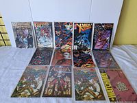 All 11 comic books laid out on a flat surface upright and flat, showing various covers including X-Men Classic, Supreme, and Watchmen